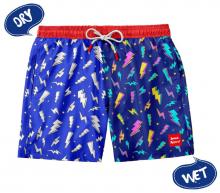blue swim shorts with a red waistband, half the shorts have a lightning strike pattern in all white with the word 'dry' above, and the other half shows a colourful lightning strike pattern with 'wet' written below it