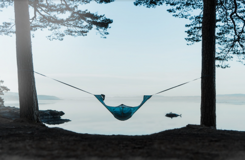 Draumr hammock hanging by a lake between two trees
