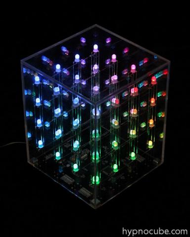 A Hypnocube lit up in rainbow LEDs in the dark