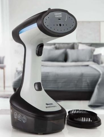 white and black garment steamer, with image of bed in the background 