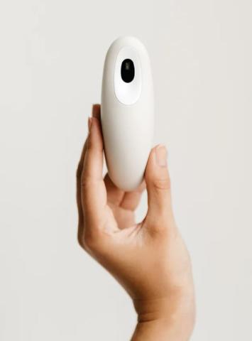 hand holding white device with black sensor on the front 