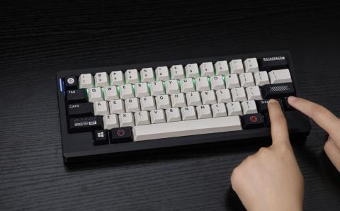 hands pressing keys on a black keyboard with white middle keys 