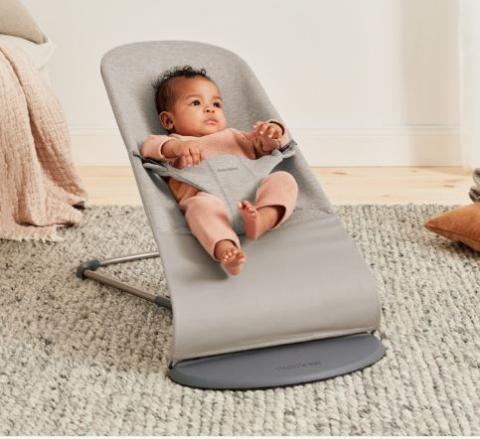 small baby in a grey/beige baby bouncer 