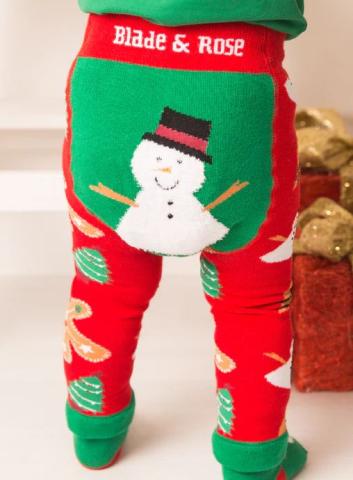 baby wearing Christmas leggings that are red with a green showman design on the back