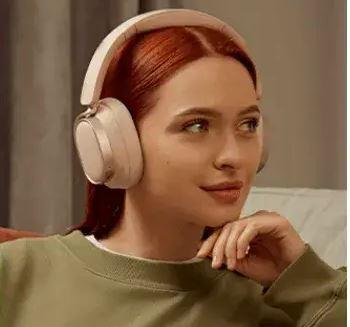 Woman wearing baby pink over ear headphones 