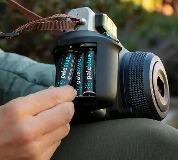 hand putting rechargeable batteries in a camera 