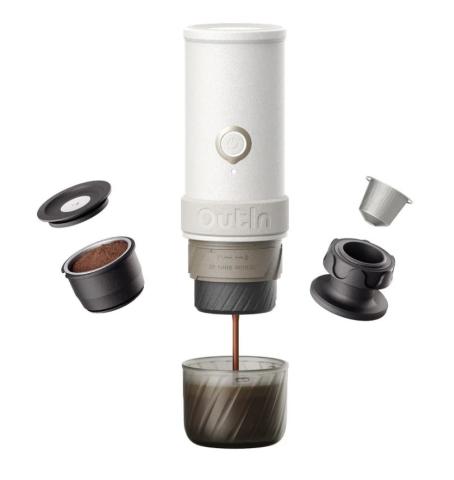 Image of a white cylindrical portable espresso maker with components on either side, including a ground coffee basket and a coffee pod holder. At the base is a glass cup catching brewed coffee. 