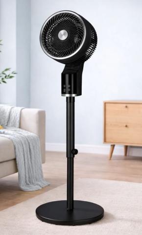 Image of black pedestal fan with circular base, in a living room setting. 
