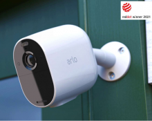 Arlo Essential Spotlight Camera in white mounted on a wall