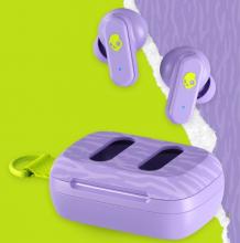 purple earbuds above the purple case which has holes to reveal the earbuds, case and buds are purple tiger print with an acid green skullcandy logo and lanyard on the case, all on the same purple tiger print and acid green split background