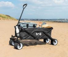 grey and black beach trolley with large handle on sand 