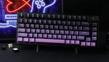 black keyboard with gradient dark purple keys at the top, to light purple/pink keys at the buttom 