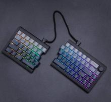 black split keyboard with rainbow colours under the keys, on a black background 