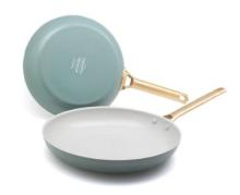 2 blue and white frying pans with a gold handles on a white background 