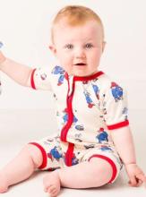 baby wearing a cream romper with red contrast piping and a Paddington pattern across it