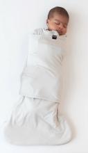 baby wrapped in a light cream coloured sleep bag/swaddle on a white background 