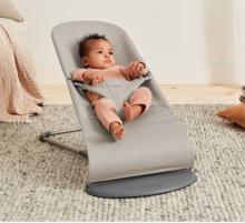 small baby in a grey/beige baby bouncer 