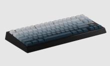 Black keyboard with a gradient colourway of white to blue/teal across the keys, on a white background 