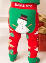 baby wearing Christmas leggings that are red with a green showman design on the back