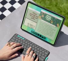 tablet on stand, with keyboard in front with hands typing on it
