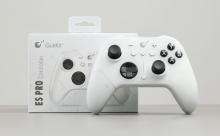 White gaming controller with black buttons and joysticks, displayed in front of its box