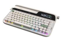 Image of keyboard with a retro typewriter inspired design, featuring round white keys, and a built in digital display. There is rainbow coloured lights coming from underneath the keys. 