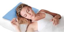 image of person laying with her head on a pillow with a blue cooling pad on top of it