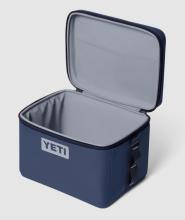 Image of open navy insulated cool box with YETI logo on the front. The box has a light grey interior. 