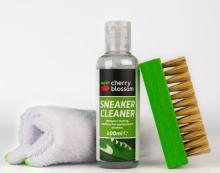 Image of white cloth, a green and black bottle labelled 'Cherry Blossom Sneaker Cleaner', and a green handled brush. The products are on a white background. 